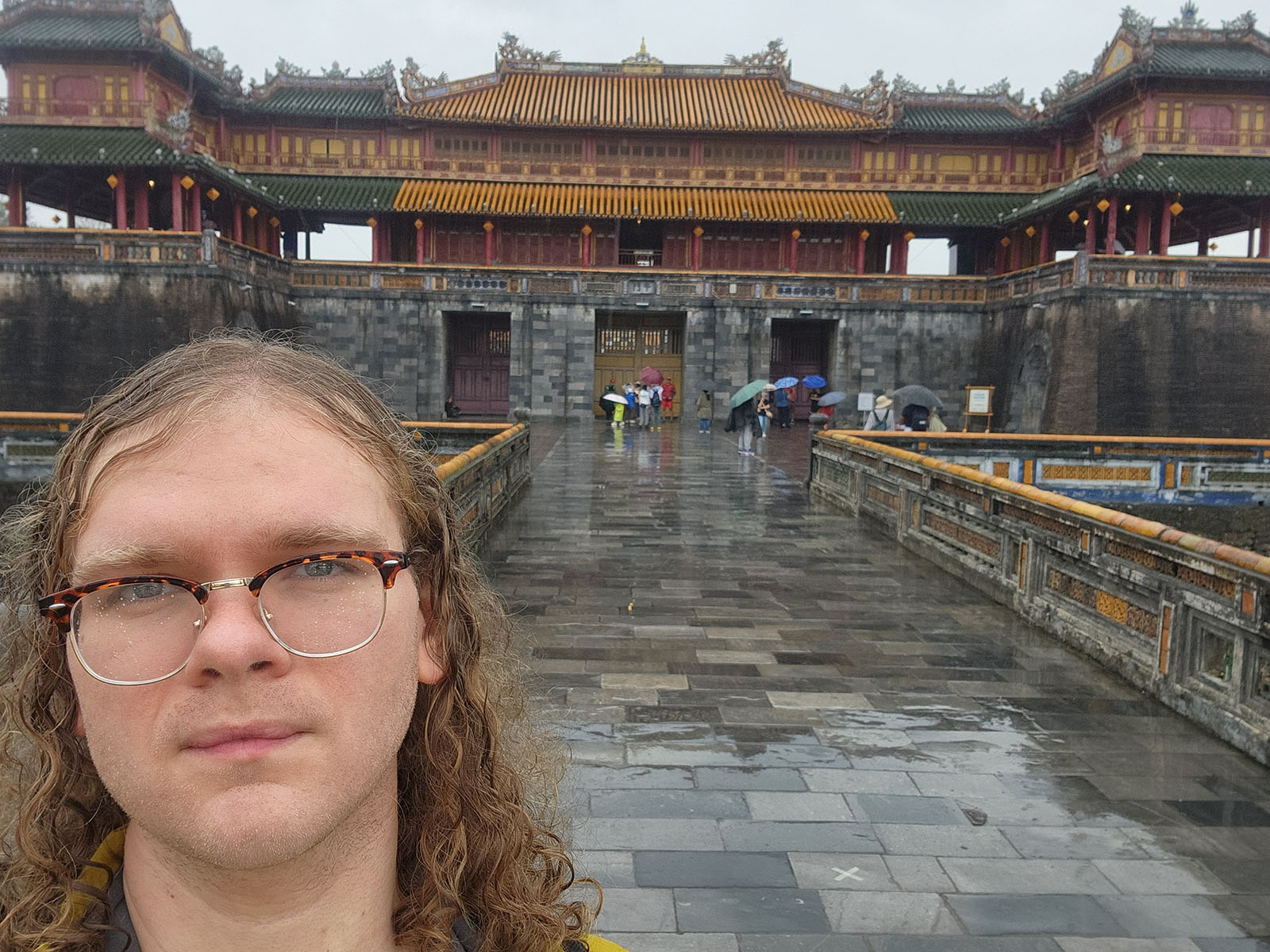 Damian's selfie in front of a set of three ornate gates.