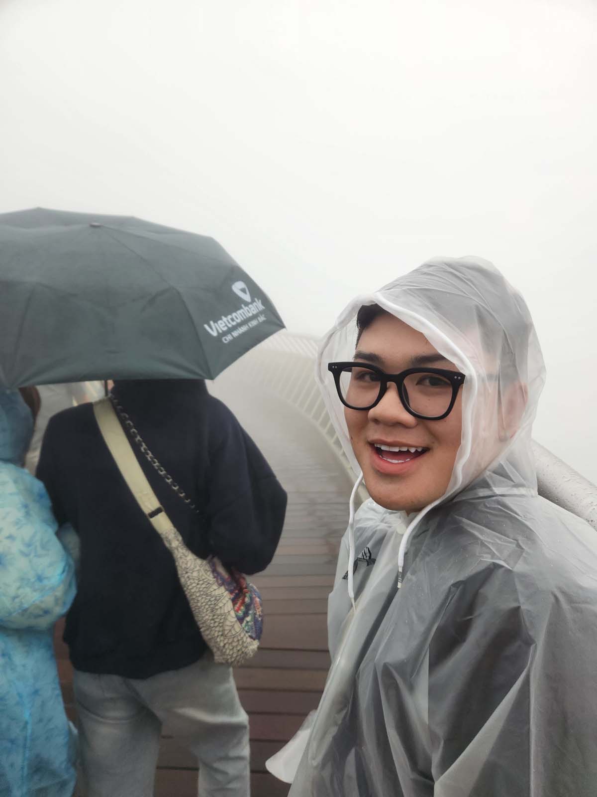A photo of Ben wearing a plastic poncho, smiling incredulously at the camera. Behind him is the Golden Bridge, but visibility through the fog is about ten feet.