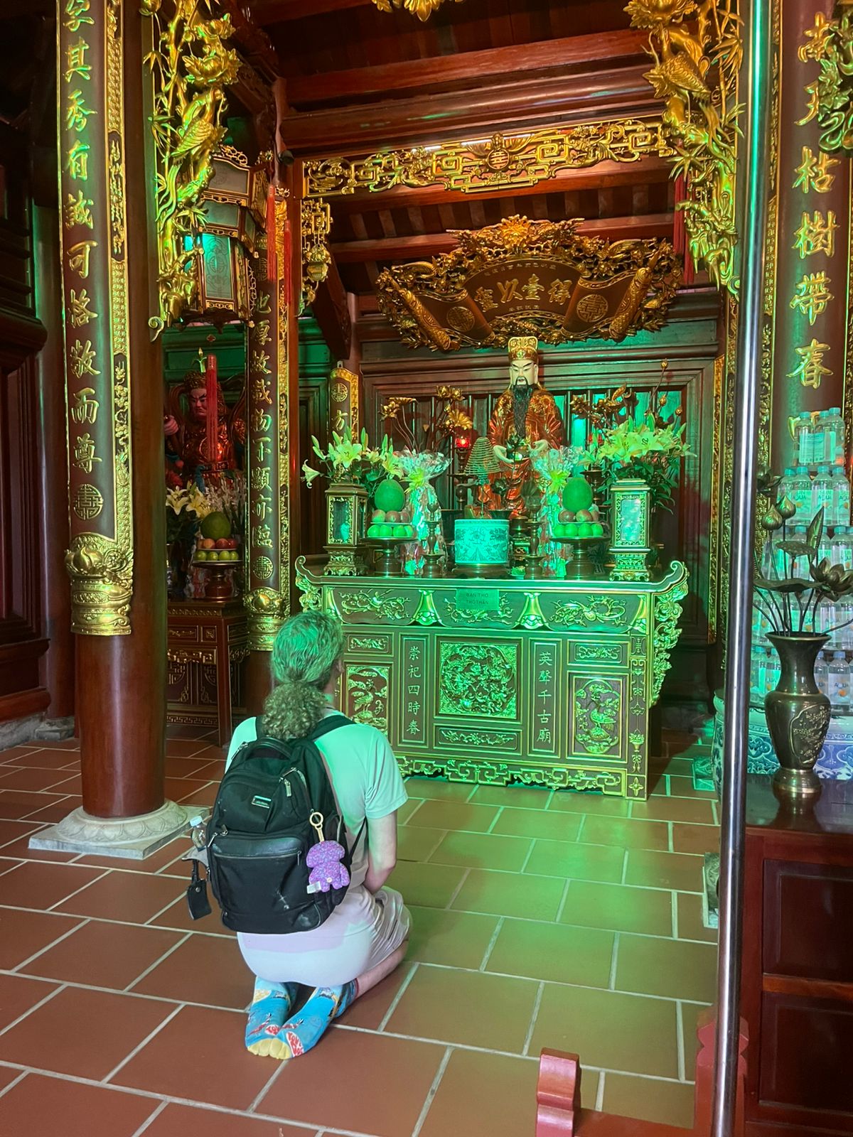 Photo of Damian genuflecting in front of an elaborate shrine.